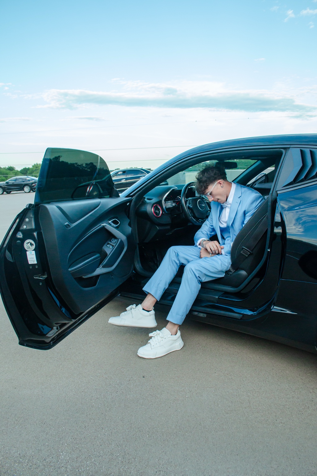 Blue suit portrait seated in an open car doorway