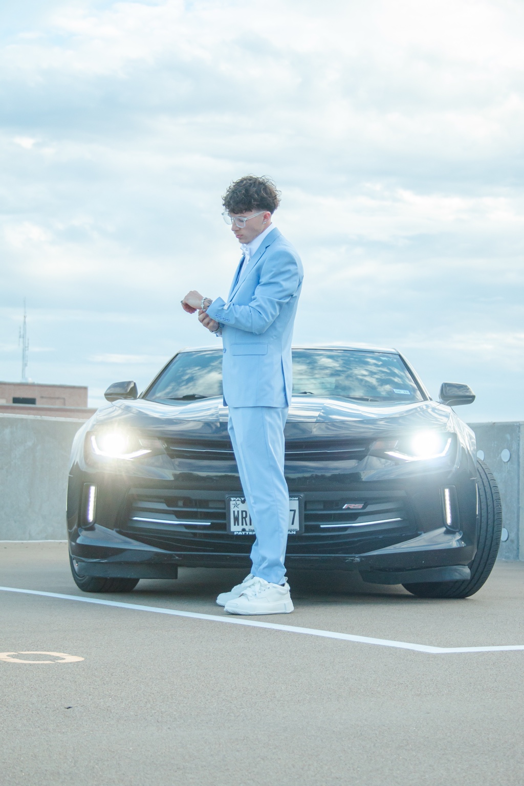 Blue suit portrait in front of car headlights