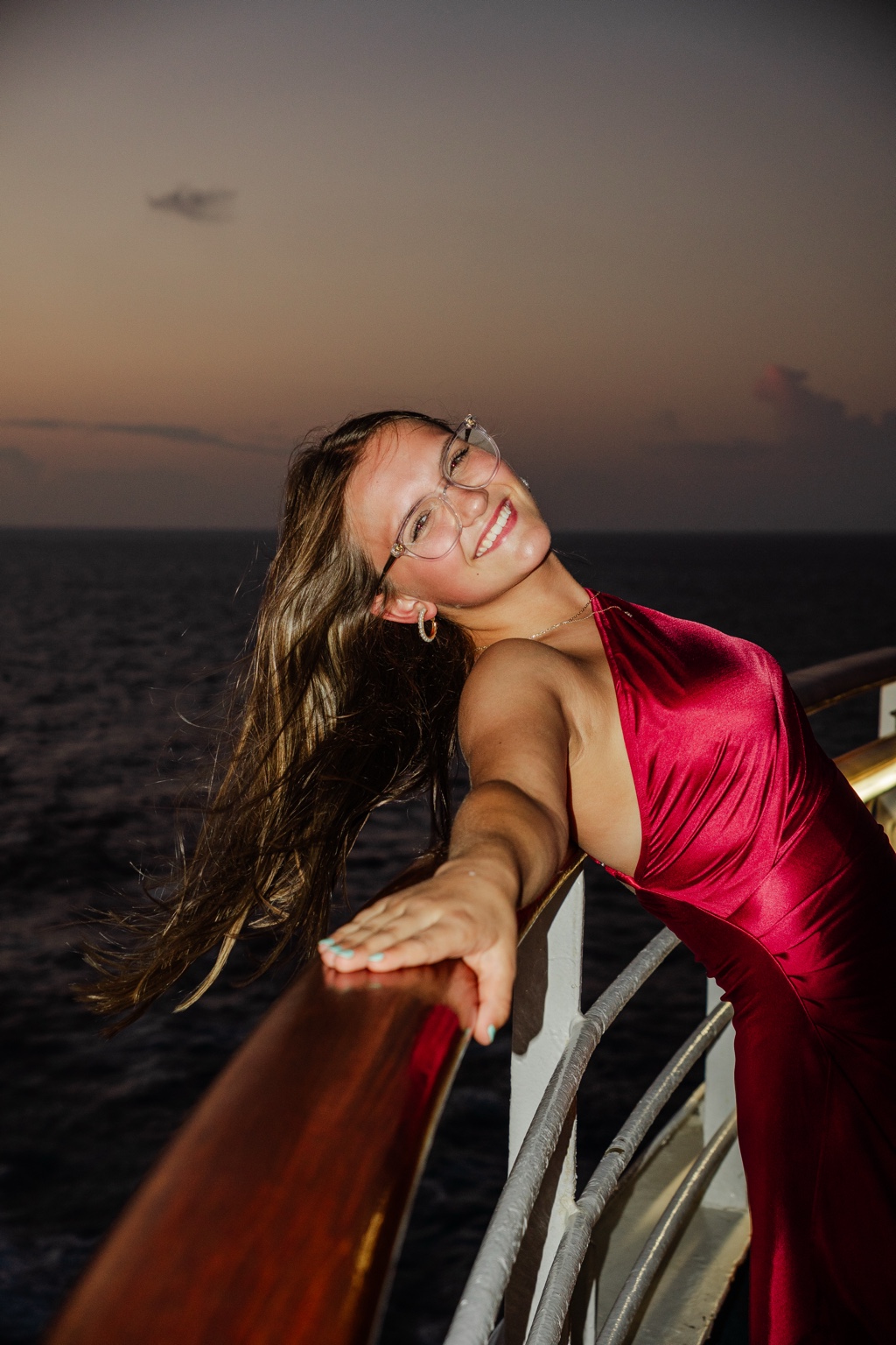 Close portrait in a red dress leaning along a railing