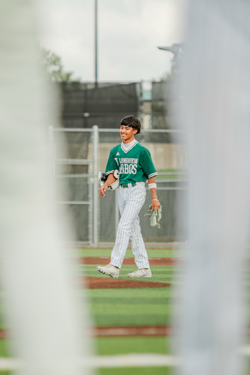 Baseball player framed through foreground structures