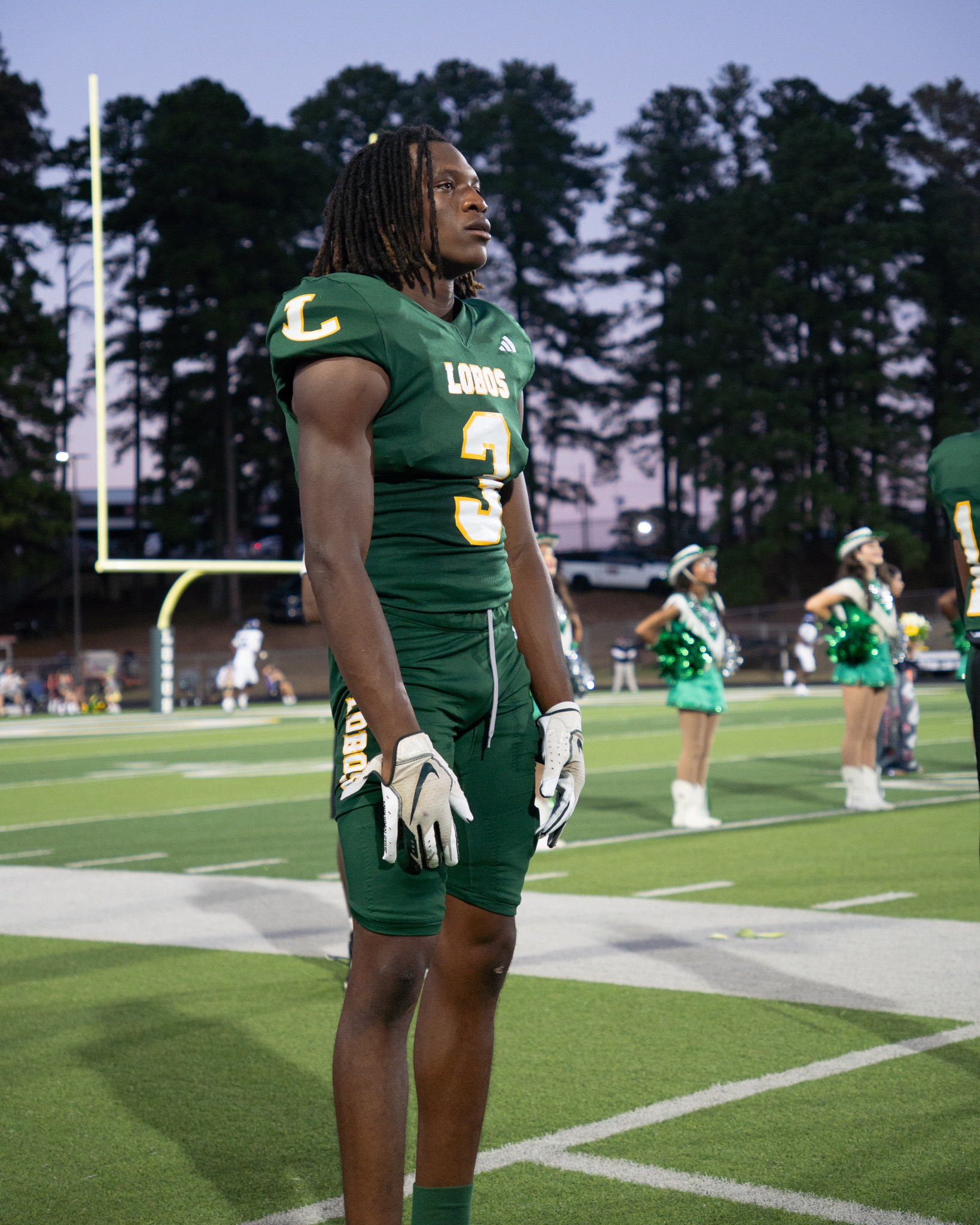 Longview player number 3 on the sideline at dusk