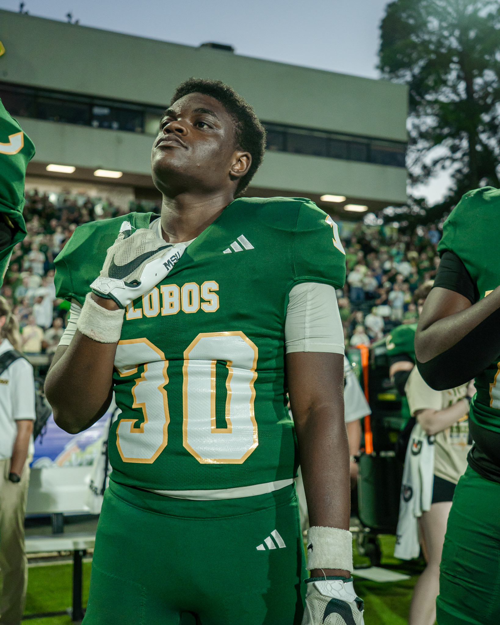 Longview player number 30 standing with a gloved hand over his chest