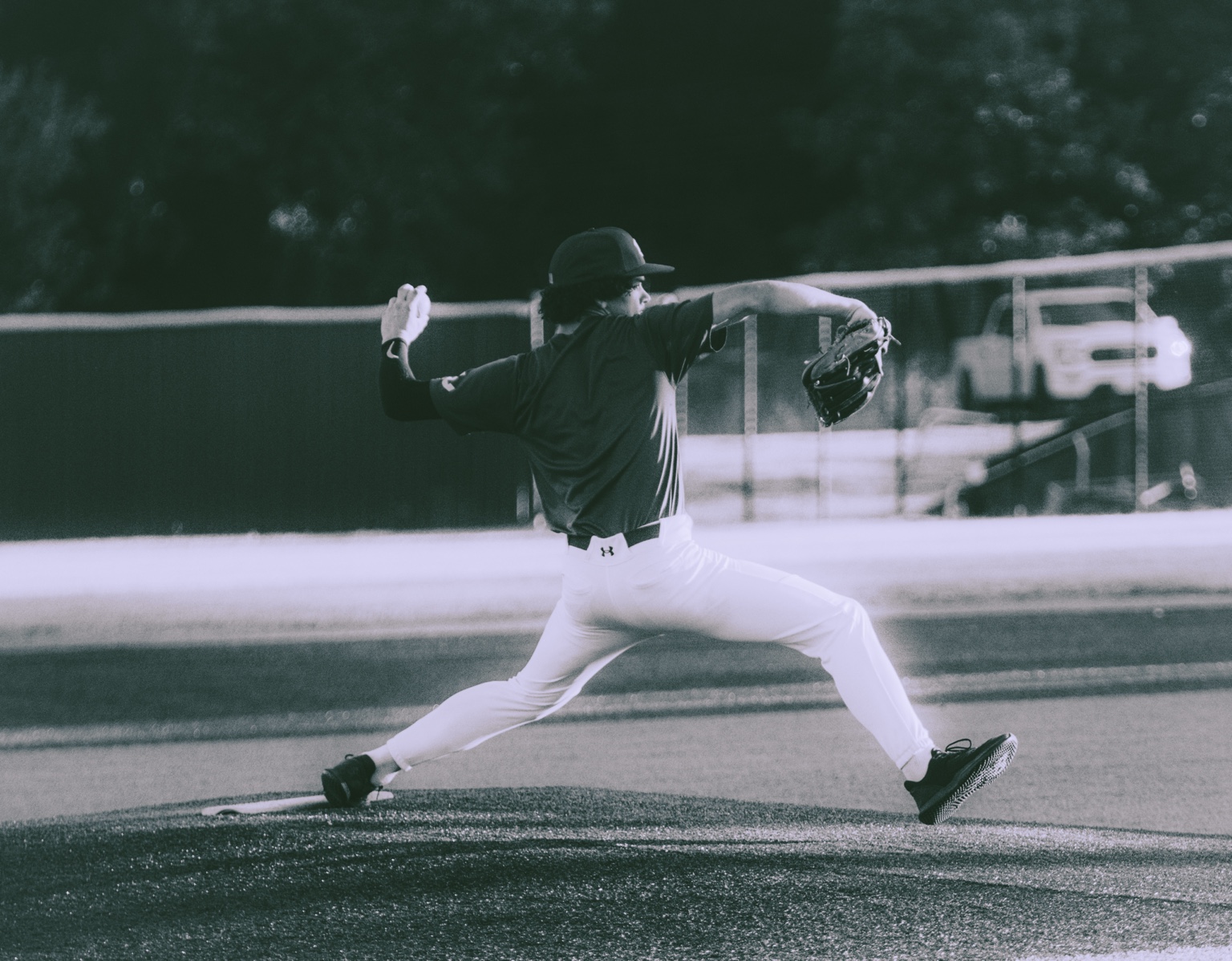 Black-and-white photograph of a baseball pitcher mid-delivery