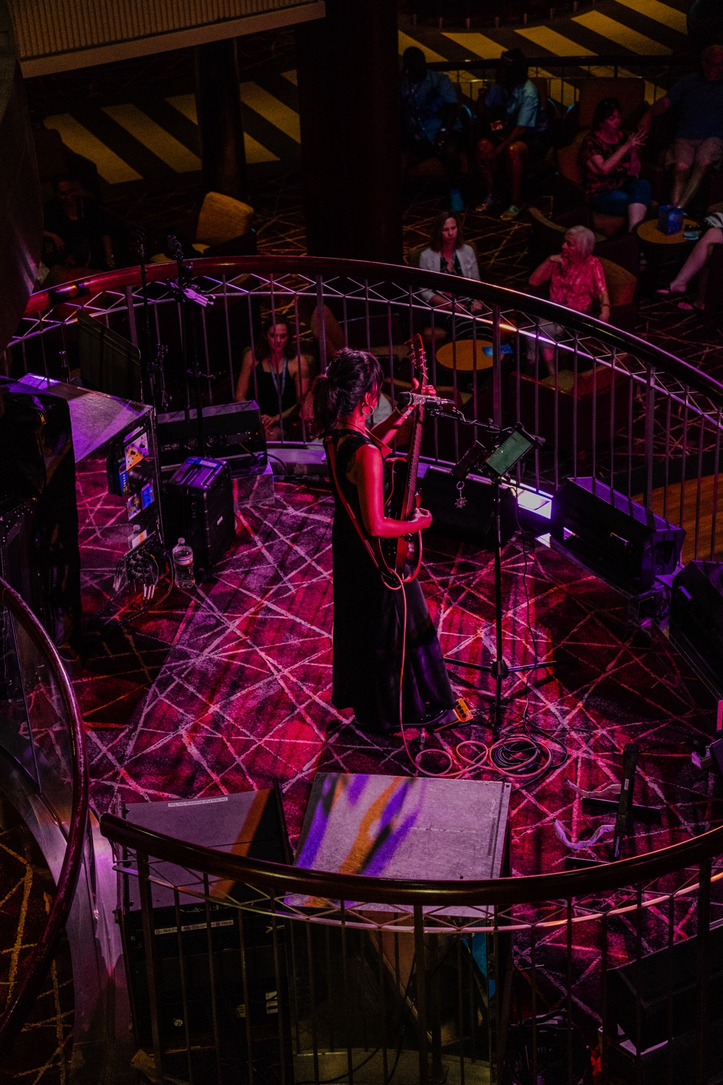 Live musician performing under magenta stage light